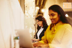 two females working on their laptop