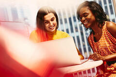 Two smiling women working together