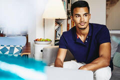 Man sitting on couch working on laptop. 