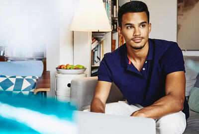 lettre-de-presentation-body.jpg Man sitting on couch working on laptop.