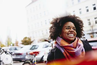 Smiling woman looking up while walking outside. Smiling woman looking up while walking outside.