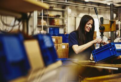Smiling woman working on a production site. Smiling woman working on a production site.